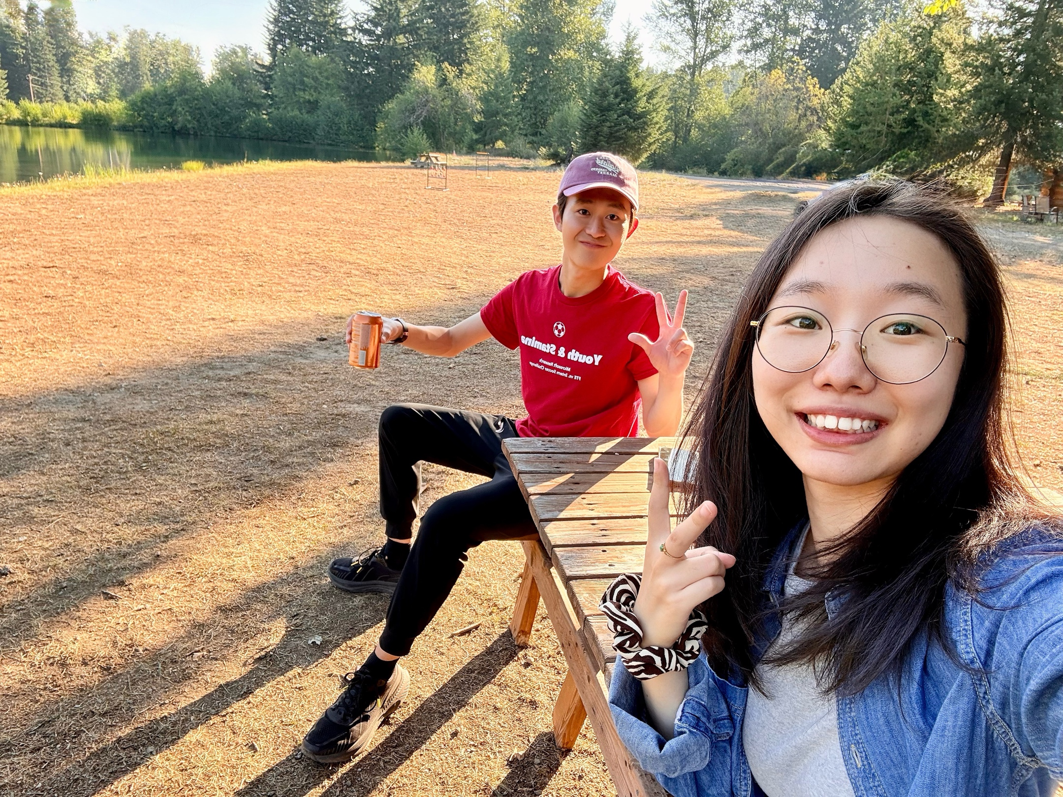 A birthday camping photo beside a picnic table in a sunlit clearing.